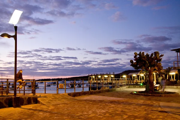 Unidentified tourist admiring magical sunset along the port in San Cristobal island, Galapagos — Stock Photo, Image