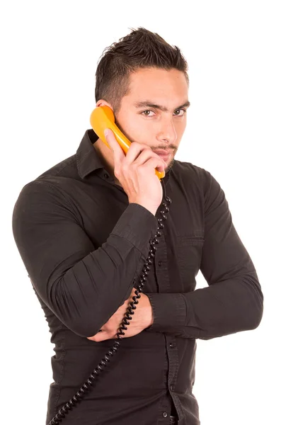 Portrait rapproché d'un bel homme hispanique parlant sur un téléphone rétro filaire — Photo
