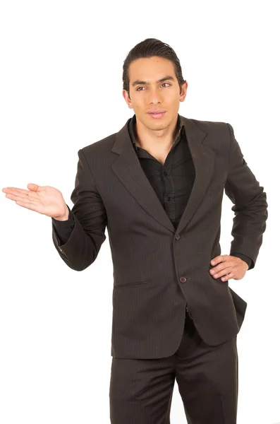 Przystojny młody mężczyzna ubrany garnitur pozowanie przedstawienie informacji z jego strony — Zdjęcie stockowe