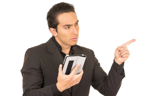 Handsome young man wearing a suit posing using tablet pointing to the side — Stock Photo, Image