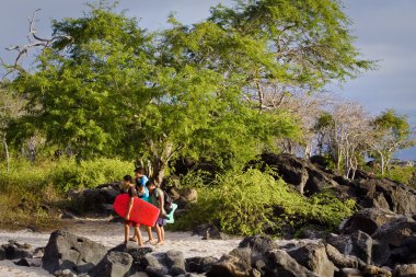 Kimliği belirsiz genç genç çocukların kendi su kurulları taşıyan Sahilde yürüyüş