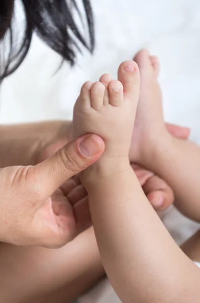 Primo piano colpo di madri mani tenendo babys piedi — Foto Stock