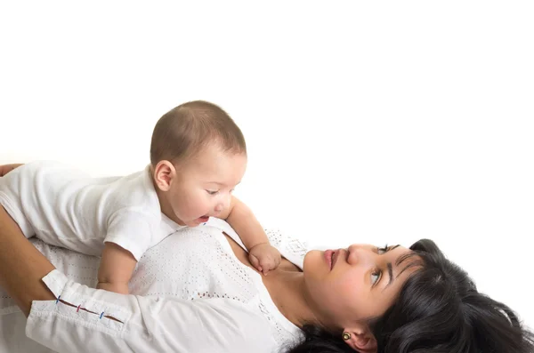 Hermosa mujer joven acostada sosteniendo adorable bebé — Foto de Stock