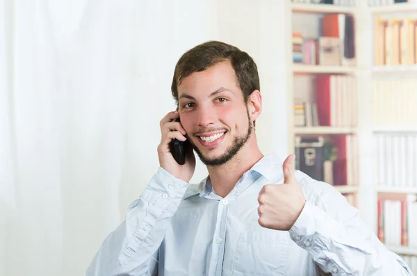 Mladý pohledný muž pomocí mobilního telefonu — Stock fotografie