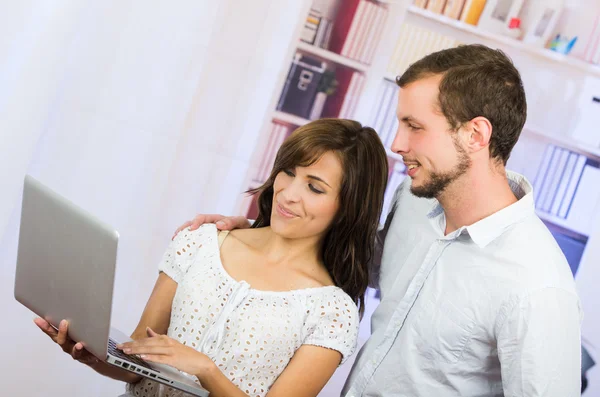 Young casual attractive couple using laptop — Stock Photo, Image