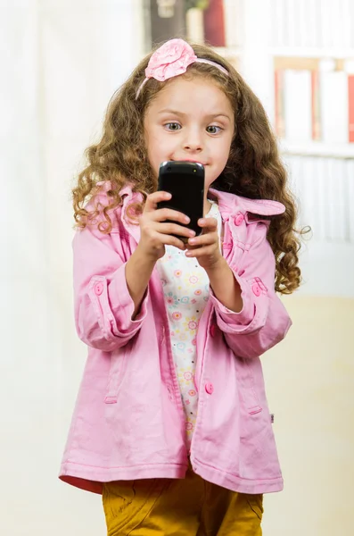 Schattig klein meisje met behulp van mobiele telefoon — Stockfoto