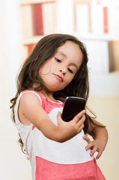 Schattig klein meisje met behulp van mobiele telefoon met een selfie — Stockfoto