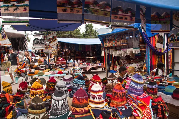Barevné textilní stánek s klobouky na populární Otavalo trhu, Ekvádor — Stock fotografie