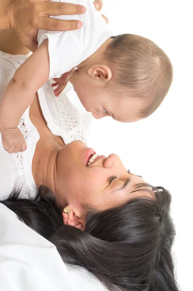 Beautiful young woman lying down holding adorable baby — Stock Photo, Image