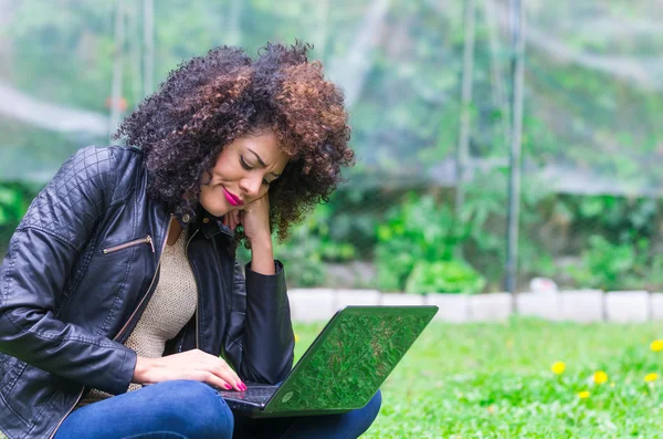 Exotische mooi jong meisje met behulp van laptop in de tuin — Stockfoto