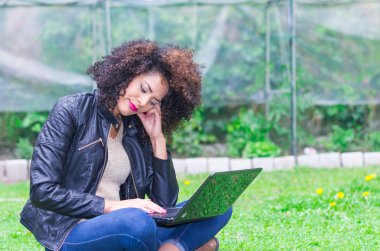 egzotik güzel genç kız bahçede dizüstü bilgisayar kullanarak