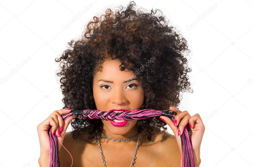 exotic beautiful young girl with dark curly hair holding whip posing