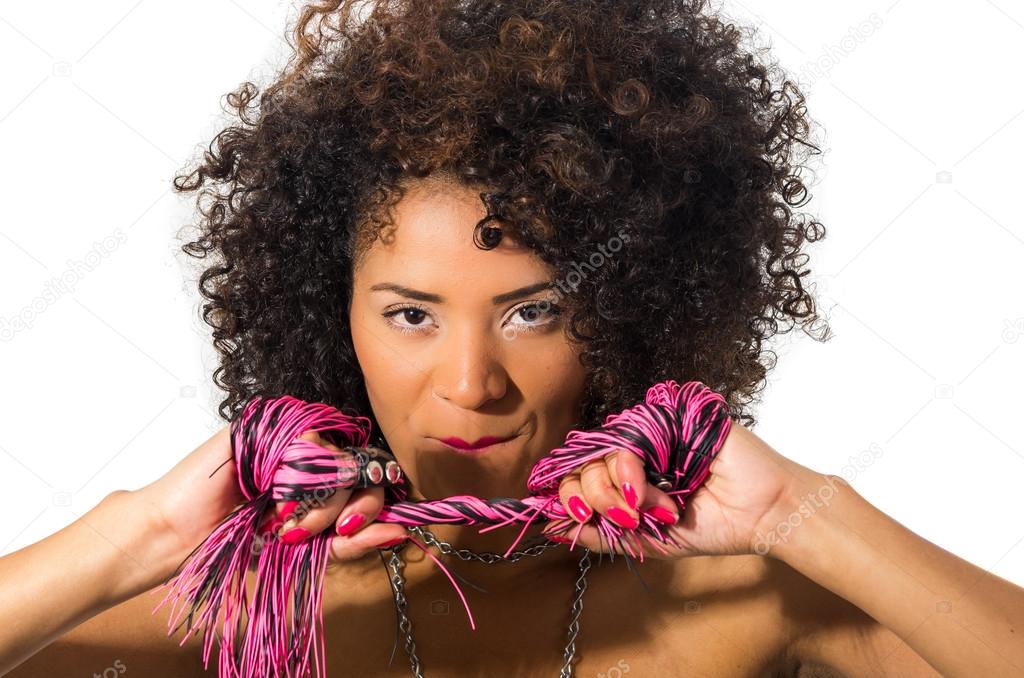 exotic beautiful young girl with dark curly hair holding whip posing