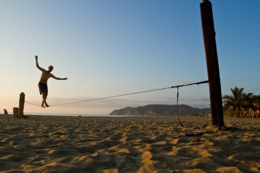 Kimliği belirsiz adam slackline bir plaj Manabi, Ekvator üzerinde Dengeleme