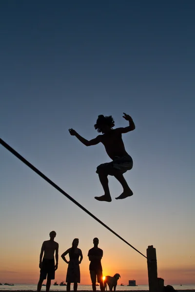 Silhouette di giovane uomo in equilibrio su slackline in una spiaggia di Manabi, Ecuador — Foto Stock