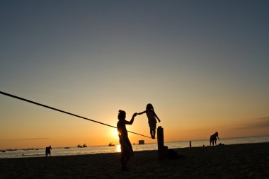 Küçük kız Manabi, Ekvator bir plajda slackline Dengeleme silüeti