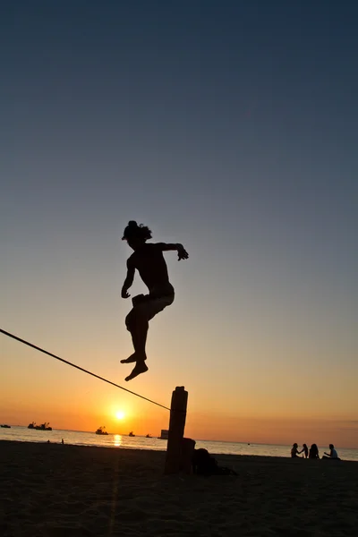 Silhouette di giovane uomo in equilibrio su slackline in una spiaggia di Manabi, Ecuador — Foto Stock