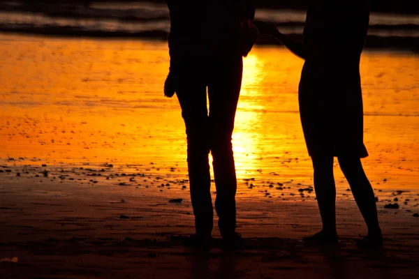 Silhouette di coppia in spiaggia durante il tramonto — Foto Stock