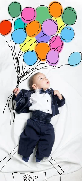 Cute baby boy decorated flying with balloons — Stock Photo, Image