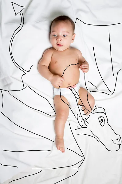 Cute baby boy decorated riding a dragon — Stock Photo, Image