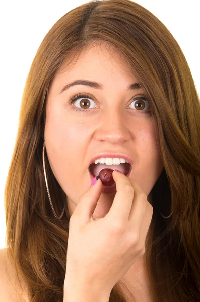 Beautiful young supersticious woman eating grapes — Stock Photo, Image