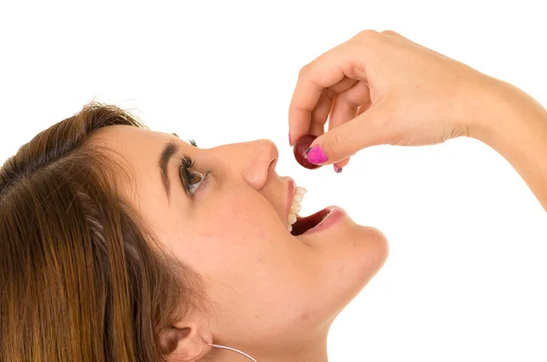 Beautiful young supersticious woman eating grapes — Stock Photo, Image