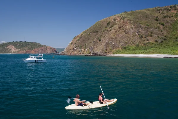 Turistas no identificados disfrutando de un paseo en kayak en una hermosa playa paradisíaca, la isla de Salango. Manabí, Ecuador — Foto de Stock