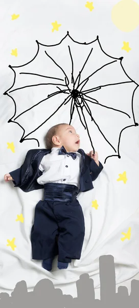 Cute baby boy decorated flying with an umbrella — Stock Photo, Image