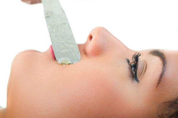 Beautiful young woman getting mustache waxing