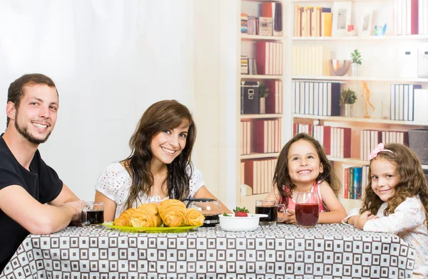 Nette Familie mit zwei Mädchen beim Frühstück — Stockfoto