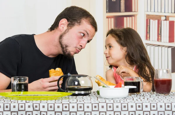 Fun loving dad having breakfast with small daughter — Stock Photo, Image