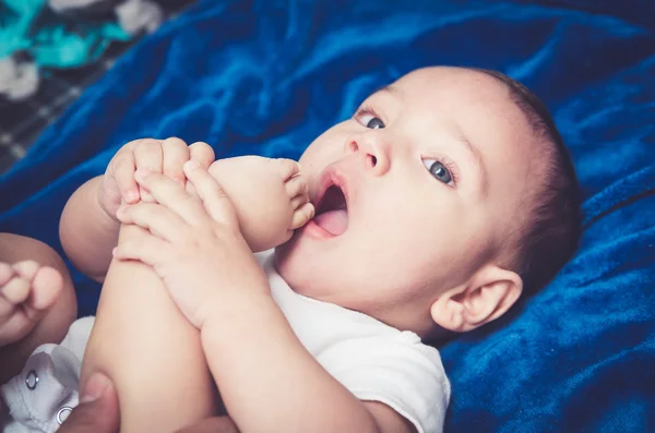 Cute baby boy lying on a blanket sucking his toe — Stock Photo, Image