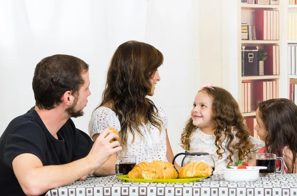 Beautiful young happy family eating meal — Stock Photo, Image