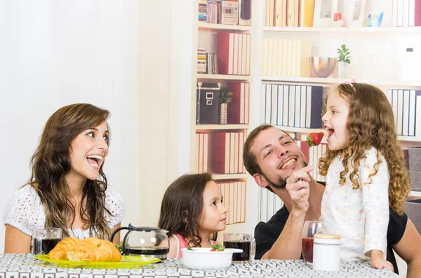 Söt familj med två flickor äter frukost — Stockfoto