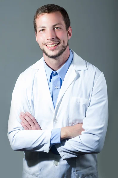 Retrato de primer plano del guapo y joven doctor cruzando brazos — Foto de Stock