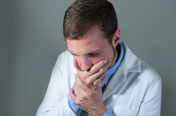 Retrato de primer plano del joven médico sorprendido cubriendo la boca — Foto de Stock