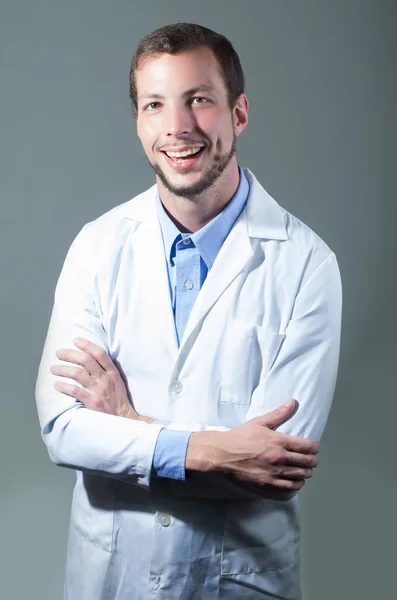 Retrato de primer plano del guapo y joven doctor cruzando brazos — Foto de Stock