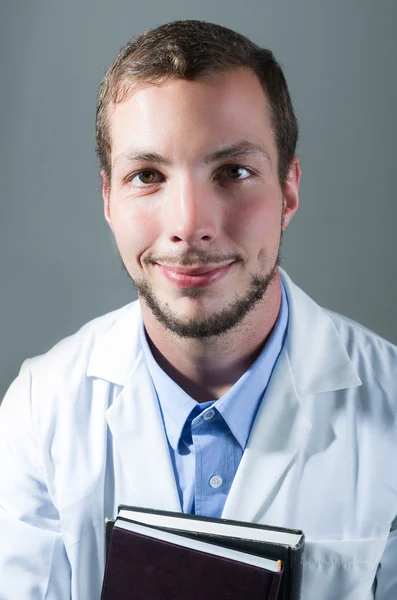 Jóképű fiatal orvos, tartja a könyvet closeup portréja — Stock Fotó