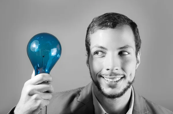 Stilig ung smart man innehar en blå glödlampa — Stockfoto