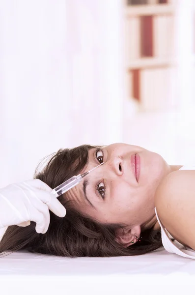 Chica joven acostada lista para recibir una inyección cosmética en su cara —  Fotos de Stock