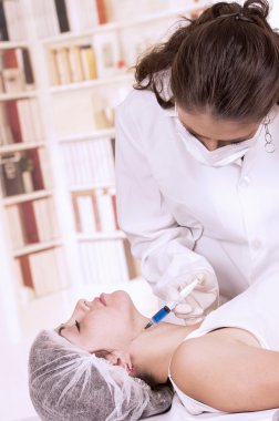 Onun karşısında kozmetik bir enjeksiyon almak için aşağı hazır yalan genç kız