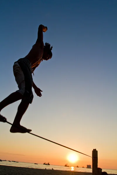 Silueta de joven balanceándose en slackline en una playa en Manabí, Ecuador —  Fotos de Stock