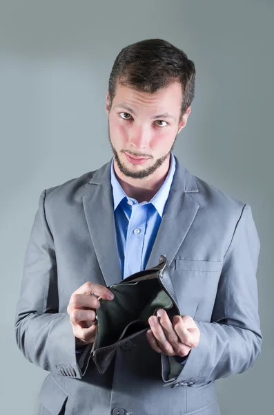 Retrato de homem bonito jovem segurando carteira vazia — Fotografia de Stock