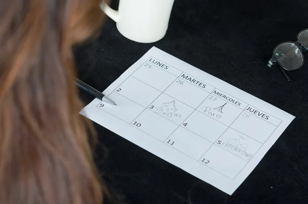 Close-up van kleine kalender liggend op tafel naast pen en koffie mok — Stockfoto