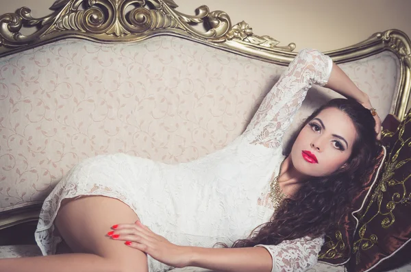 Bella ragazza modello seduta sul divano vittoriano in posa per la fotocamera — Foto Stock
