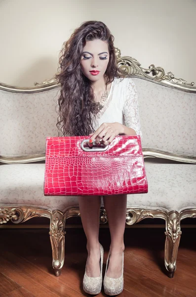 Pretty model girl sitting on victorian sofa posing for camera — Stock Photo, Image