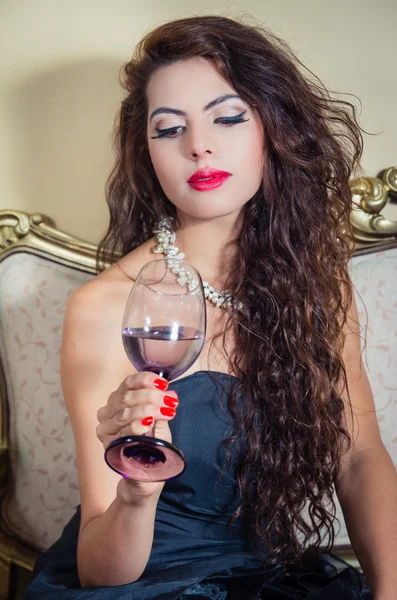 Pretty model girl sitting on victorian sofa posing for camera — Stock Photo, Image