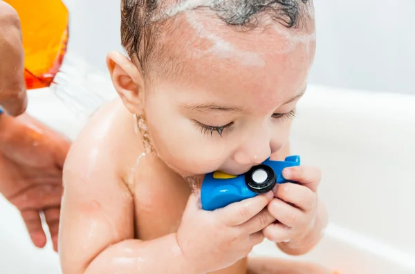 Sweet baby playing with toy during bath — Stock Photo, Image