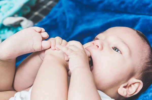 Cute baby boy lying on a blanket sucking his toe — Stock Photo, Image