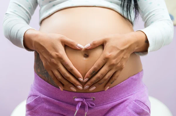Femme enceinte montrant le ventre à la caméra — Photo
